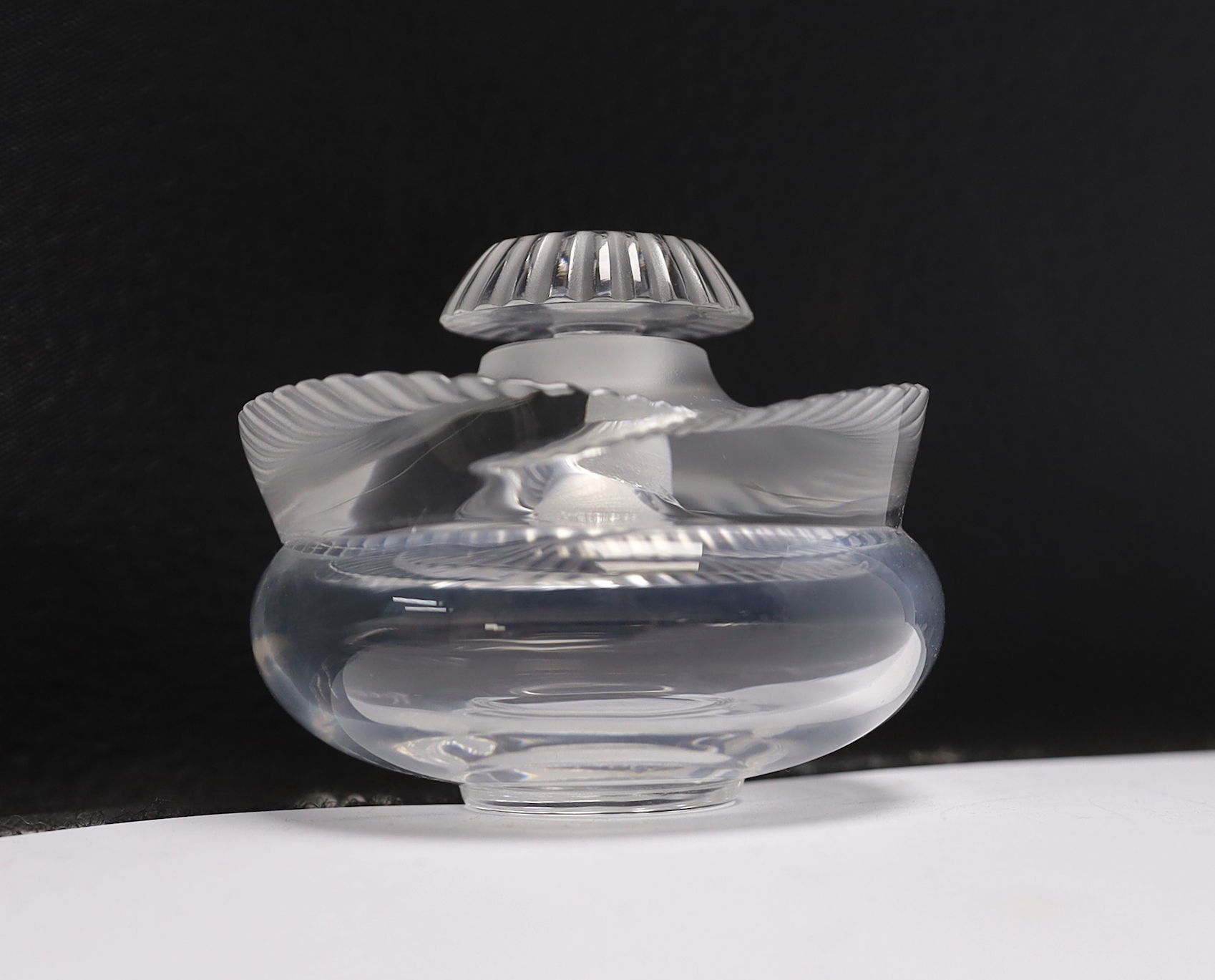 Three Lalique glass scent bottles and stoppers, one with Lily of the Valley stopper, 12cm